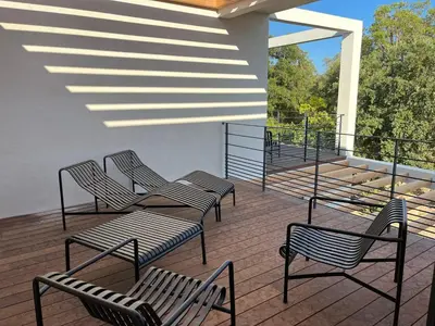 a deck with three chairs and a table at A Cupulata in Porto-Vecchio