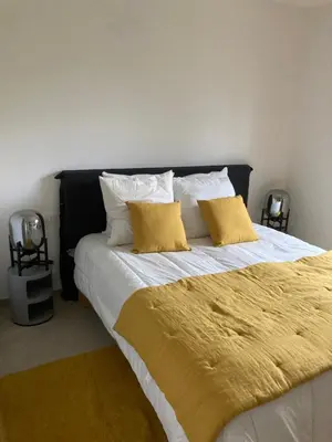 a bedroom with a large bed with two yellow pillows at A Cupulata in Porto-Vecchio