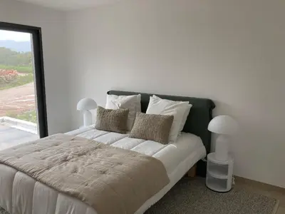 a bedroom with a large bed with a large window at A Cupulata in Porto-Vecchio