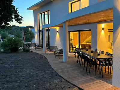 a wooden deck with tables and chairs on a house at A Cupulata in Porto-Vecchio