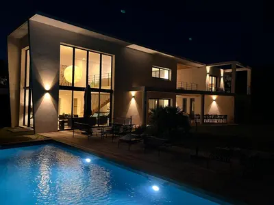 a house with a swimming pool at night at A Cupulata in Porto-Vecchio