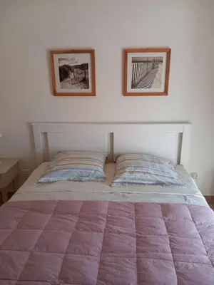 a bed in a bedroom with two pictures on the wall at Chez Rachel chambre et salle bain privative chez l'habitant in Aléria