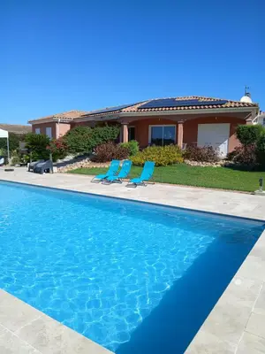 a swimming pool with two chairs and a house at Chez Rachel chambre et salle bain privative chez l'habitant in Aléria
