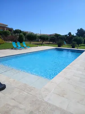 a swimming pool with blue chairs in a yard at Chez Rachel chambre et salle bain privative chez l'habitant in Aléria