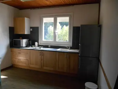 a kitchen with a black refrigerator and a window at B&B la rivière in Penta-di-Casinca