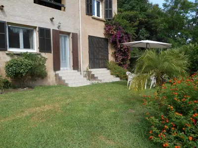 a house with an umbrella and a chair in the yard at B&B la rivière in Penta-di-Casinca