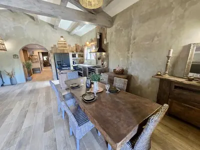 a kitchen and dining room with a wooden table and chairs at U Loghju in Oletta