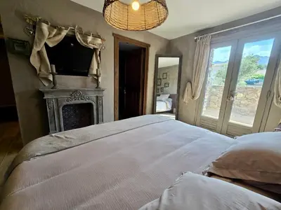 a bedroom with a bed with a fireplace and a television at U Loghju in Oletta