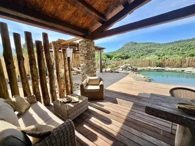 a patio with a table and chairs on a wooden deck at U Loghju in Oletta