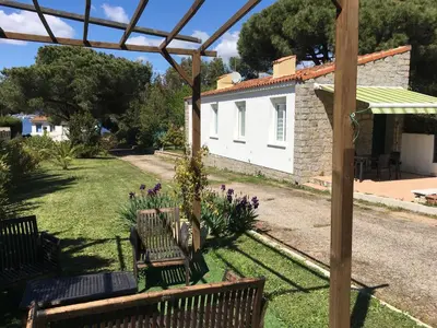 a group of benches in a yard with a house at Maisonnette 2 minutes pied plage in Grosseto-Prugna
