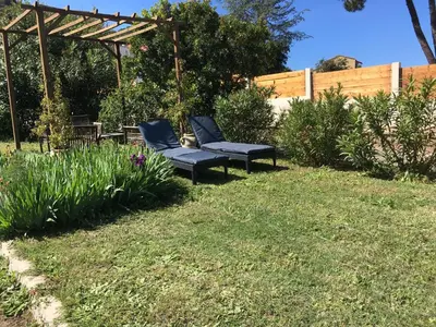two blue chairs sitting in the grass in a yard at Maisonnette 2 minutes pied plage in Grosseto-Prugna