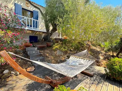 a hammock on a deck in front of a house at Villa Paomia in Cargèse