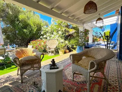a patio with a table and chairs and a blue wall at Villa Paomia in Cargèse