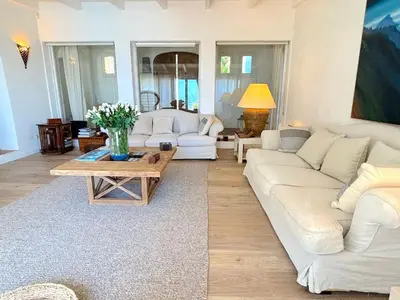 a living room with white couches and a coffee table at Villa Paomia in Cargèse