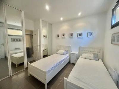 a bedroom with two beds and a mirror at Villa d'exception à Tizzano in Sartène