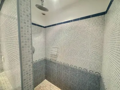a bathroom with a shower with white tiled walls at Villa d'exception à Tizzano in Sartène