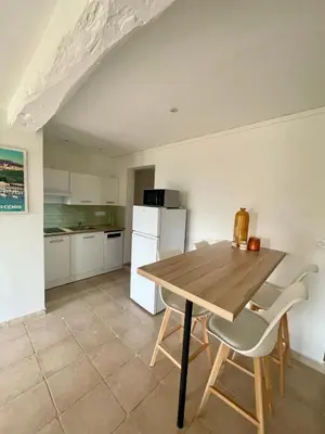 a kitchen with a wooden table and two chairs at Dolce Corsica in Porto-Vecchio