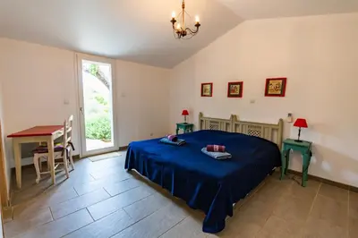 a bedroom with a bed and a table and a window at La Bergerie - Les Sittelles in Pinarellu