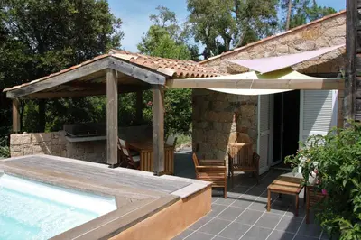 a patio with an umbrella and a swimming pool at La Bergerie - Les Sittelles in Pinarellu