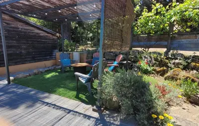 a patio with chairs and a table in a garden at La Bergerie - Les Sittelles in Pinarellu