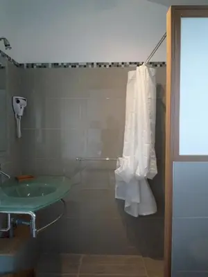 a bathroom with a sink and a towel hanging from a shower at La Bergerie - Les Sittelles in Pinarellu
