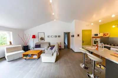 a living room with white furniture and a kitchen at La Bergerie - Les Sittelles in Pinarellu
