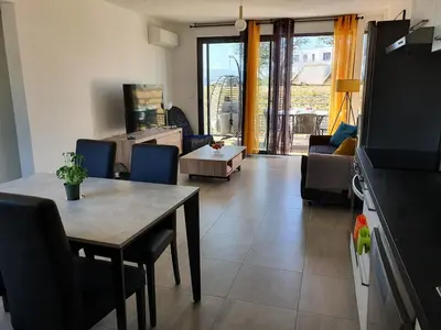 a living room with a table and a couch at T2 Yucca LCP - Beautiful 48 m2 2-room, 17 m2 terrace, new, air conditioning in Grosseto-Prugna