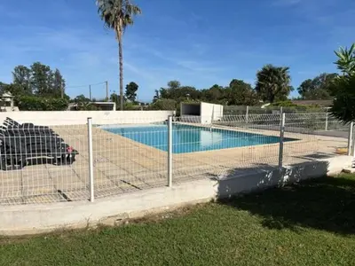 a fence in front of a swimming pool at T2 climatisé avec piscine in Prunelli-di-Fiumorbo