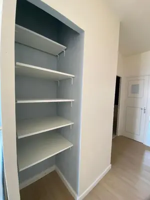 a closet with white shelves in a room at VUE MER EXCEPTIONNELLE !! Bien calme et lumineux sur la prestigieuse route des Sanguinaires à Ajaccio in Ajaccio