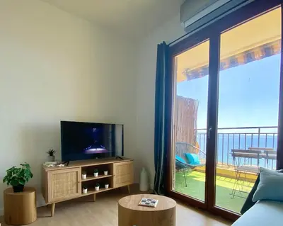 a living room with a tv and a large window at VUE MER EXCEPTIONNELLE !! Bien calme et lumineux sur la prestigieuse route des Sanguinaires à Ajaccio in Ajaccio