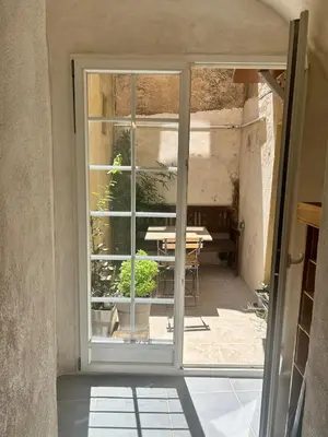 an open door to a patio with a table outside at Appartement Citadelle in Bonifacio
