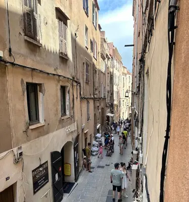 a group of people walking down a narrow street at Appartement Citadelle in Bonifacio