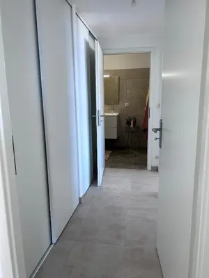 a hallway with white doors and a bathroom at Beautiful Appartment Les terrasses de Torretta room sea view Ajaccio in Ajaccio