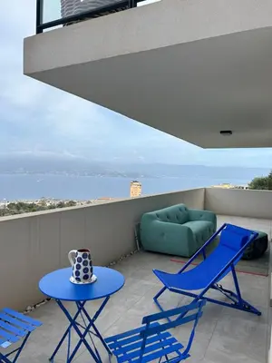 a patio with two chairs and a table and a couch at Beautiful Appartment Les terrasses de Torretta room sea view Ajaccio in Ajaccio