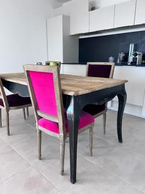 a wooden dining table with pink chairs in a kitchen at Beautiful Appartment Les terrasses de Torretta room sea view Ajaccio in Ajaccio