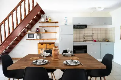 a dining room with a wooden table and chairs at maison climatisée fibrée 2 chambres à 9 min à pieds d'une grande plage in Venzolasca