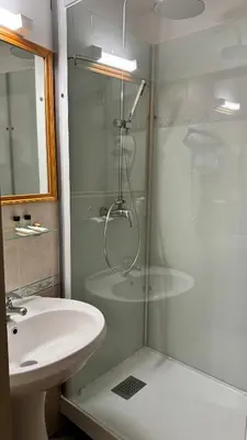 a bathroom with a shower and a sink at Colomba Hôtel Centre-Ville Historique in Bonifacio