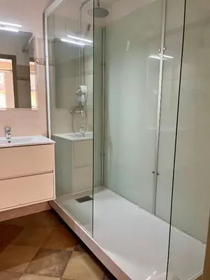 a glass shower in a bathroom with a sink at Colomba Hôtel Centre-Ville Historique in Bonifacio