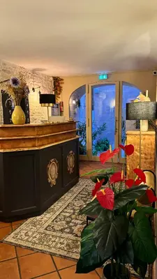 a lobby with a counter and a plant in a room at Colomba Hôtel Centre-Ville Historique in Bonifacio