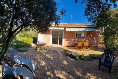 a yard with a house with a table and chairs at Maison récente entre mer et montagne in Figari