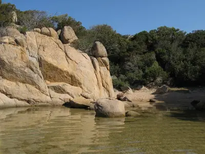 a river with some rocks in the water at Maison récente entre mer et montagne in Figari