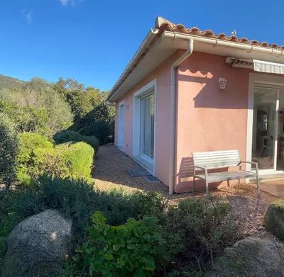a bench sitting outside of a small house at Maison récente entre mer et montagne in Figari