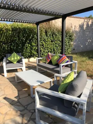 a group of chairs and a table under a pergola at Mare a Mare in Porto-Vecchio