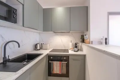 a white kitchen with a sink and a stove at T2 40m2 climatisé centre ville FESCH in Ajaccio