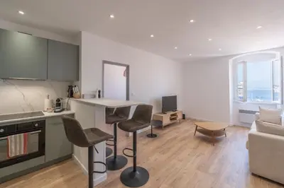 a kitchen and living room with a table and chairs at T2 40m2 climatisé centre ville FESCH in Ajaccio