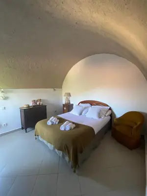 a bedroom with a bed and a chair at Location de charme au coeur de la Corse - Piscine privative - calme - nature in San-Lorenzo
