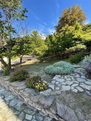 a garden with a stone path and flowers at Location de charme au coeur de la Corse - Piscine privative - calme - nature in San-Lorenzo