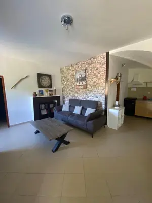 a living room with a couch and a table at Location de charme au coeur de la Corse - Piscine privative - calme - nature in San-Lorenzo