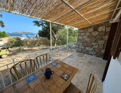 a table and chairs on a balcony with a view of the ocean at Casa Amore Pinarello in Zonza