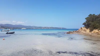 a beach with a boat in the water at Casa Amore Pinarello in Zonza